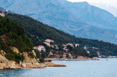 Akşam Sahil kayalar, ağaçlar ve dağlar Brela, Hırvatistan Adriyatik Denizi