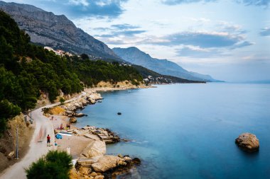 Akşam Sahil kayalar, ağaçlar ve dağlar Brela, Hırvatistan Adriyatik Denizi