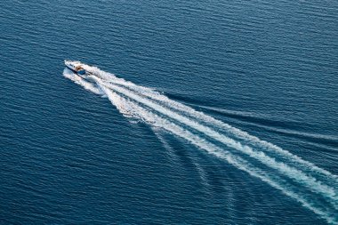 Üstten Görünüm bir küçük denizde yüzen tekne ve bir beyaz dalgalar oluşturur.