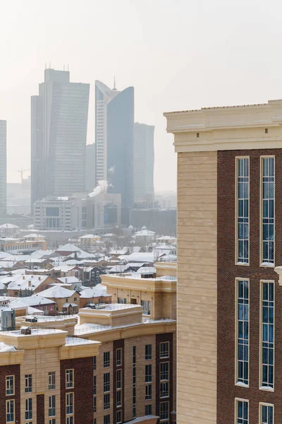Városi ellentétek, Astana, Kazahsztán. Új épület, a business center, a város magas felhőkarcolók hátterében. — Stock Fotó