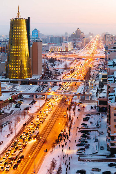 A view from above on a large avenue that goes down to the horizon, and a golden skyscraper of minestry in Astana, Kazakhstan