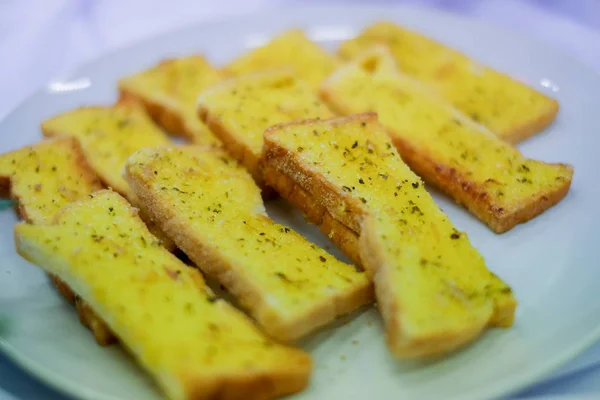Mini sarımsaklı ekmek üzerinde beyaz tabak.