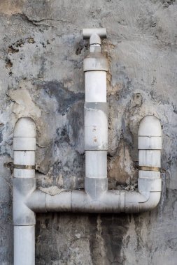 Duvardaki gri plastik su boruları