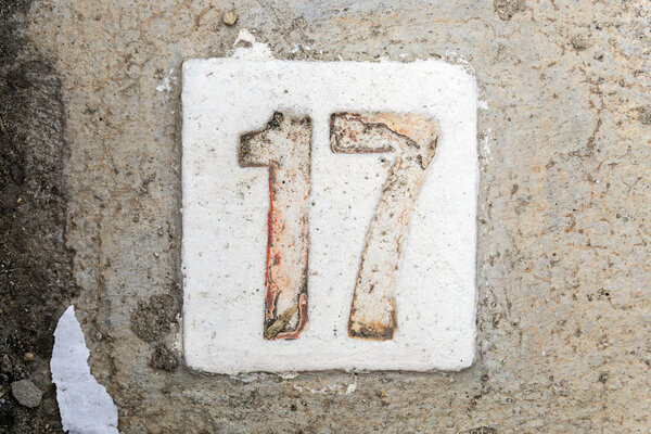 the digits with concrete on the sidewalk 17