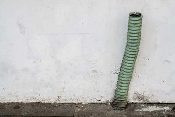 La tubería de plástico turquesa en la pared blanca sucia — Foto de Stock