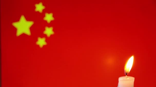 Gyászol Kínában. Égő gyertya a kínai zászló hátterében. — Stock videók