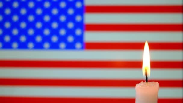 Trauer in den USA. Brennende Kerze auf dem Hintergrund der Flagge der USA . — Stockvideo