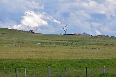 Uğursuz fırtına bulutları inişli çıkışlı yeşil tepeler ve tarım arazileri yaklaşıyor