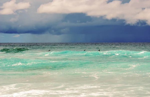 Surfers waiting for a wave with storm on horizon — Stock Photo, Image