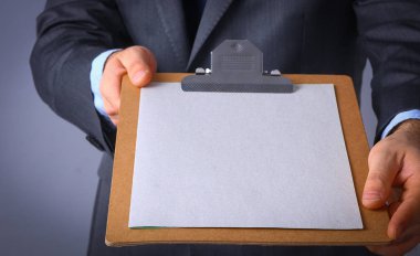 Ayakta gri arka plan üzerinde izole klasörle genç adam