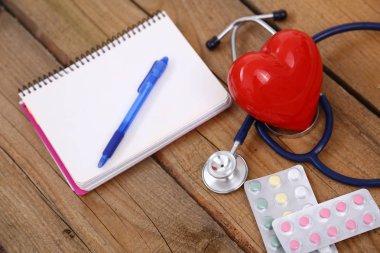 Kalp üzerinde ahşap arka plan izole bir stetoskop ile