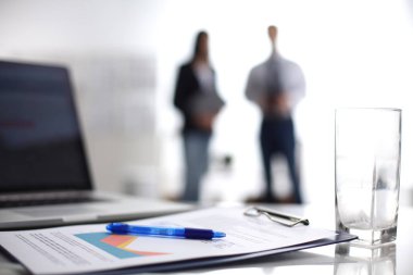 Dizüstü bilgisayar ile ağıl üstünde okul sırası, arka planda duran iki iş adamları