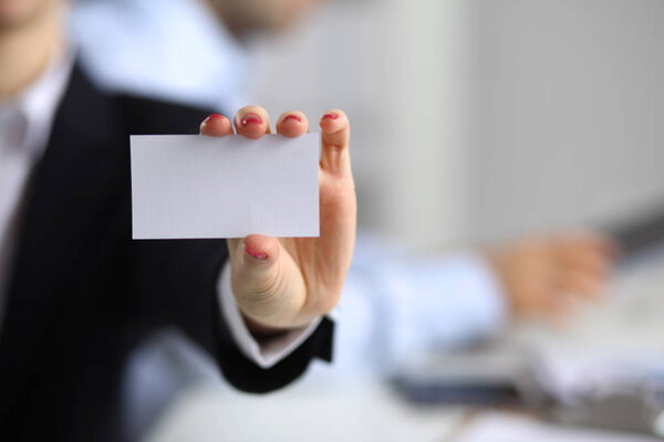 Женщина вручает визитку в офисе
