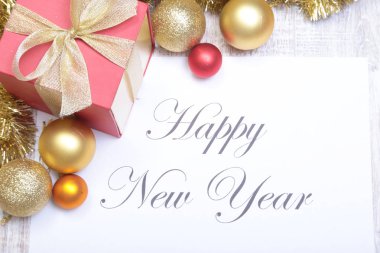 Metin neşeli Noel topları ve hediye kutusu ile kağıt üzerinde