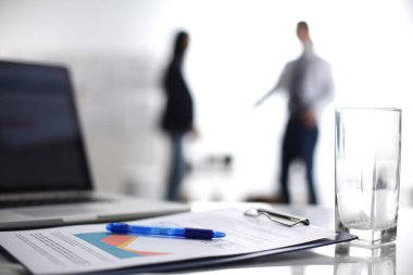 Dizüstü bilgisayar ile ağıl üstünde okul sırası, arka planda duran iki iş adamları