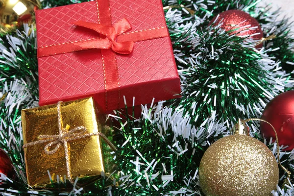 Ahşap arka plan üzerinde birçok Noel topları ile hediye kutuları — Stok fotoğraf