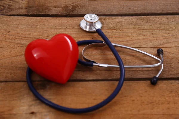 Serca stetoskopem, na białym tle na podłoże drewniane — Zdjęcie stockowe