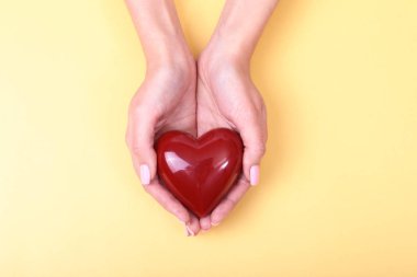 Altın arka plan üzerinde izole kırmızı kalp veren eller