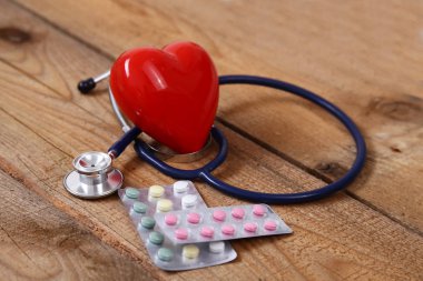 Kalp üzerinde ahşap arka plan izole bir stetoskop ile