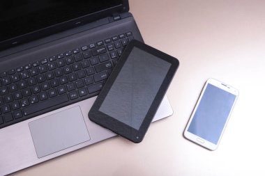 Bir telefon ve üstüne yalan tablet ile klavyenin resmi