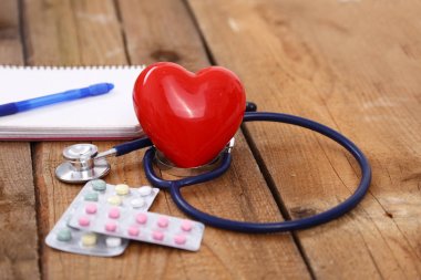 Kalp üzerinde ahşap arka plan izole bir stetoskop ile