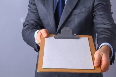 Ayakta gri arka plan üzerinde izole klasörle genç adam