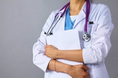 Kadın doktor beyaz arka plan üzerinde izole bir klasörle ayakta