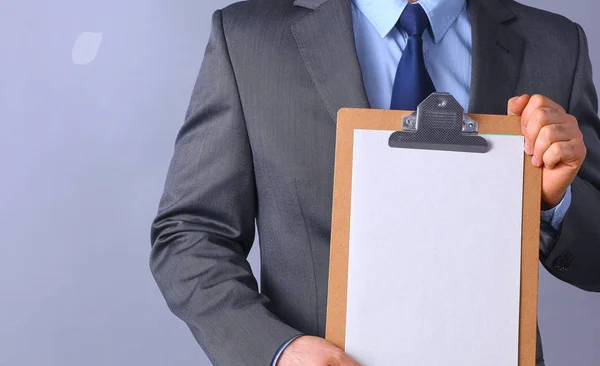 Joven de pie con la carpeta, aislado sobre fondo gris — Foto de Stock