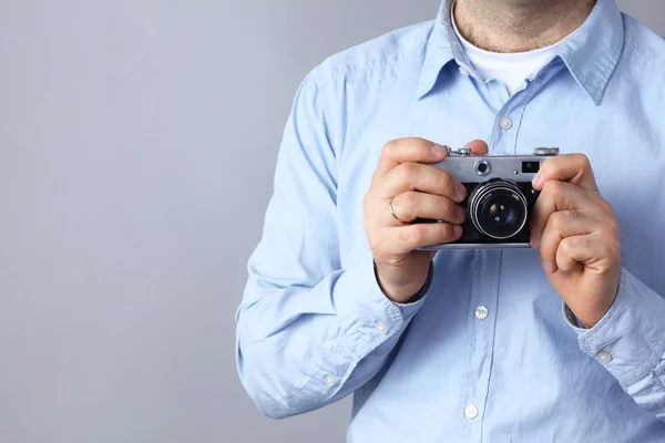 Молодой человек с камерой, изолированный на сером фоне — стоковое фото