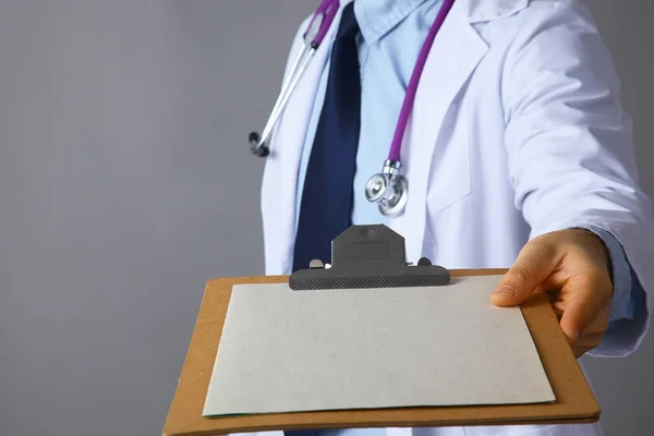 Le médecin dans un manteau blanc avec un stéthoscope tenant un dossier — Photo