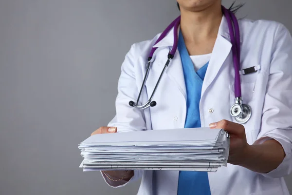Młoda lekarka dajac stosu dokumentów z medyczny stetoskop — Zdjęcie stockowe