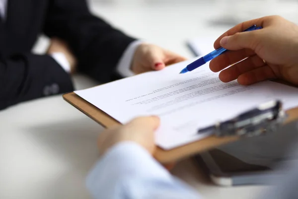 Primo piano di una mano esecutiva che tiene una penna e indica dove firmare un contratto in ufficio — Foto Stock
