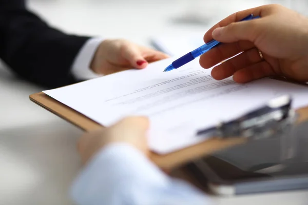 Primo piano di una mano esecutiva che tiene una penna e indica dove firmare un contratto in ufficio — Foto Stock