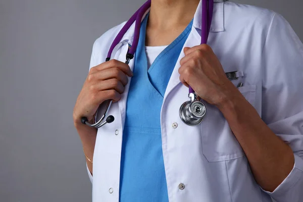Jeune femme médecin avec stéthoscope médical debout sur fond gris — Photo