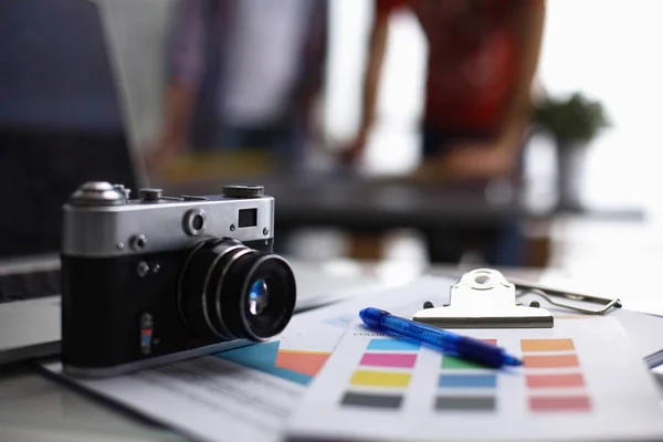 Ноутбук и камера на столе с папкой — стоковое фото