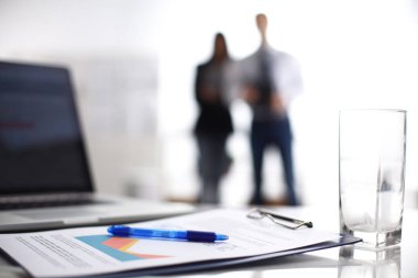 Dizüstü bilgisayar ile ağıl üstünde okul sırası, arka planda duran iki iş adamları