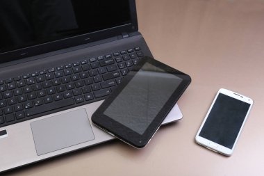 Bir telefon ve üstüne yalan tablet ile klavyenin resmi