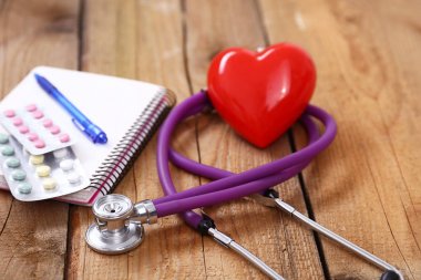 Kalp üzerinde ahşap arka plan izole bir sağlık stetoskop ile