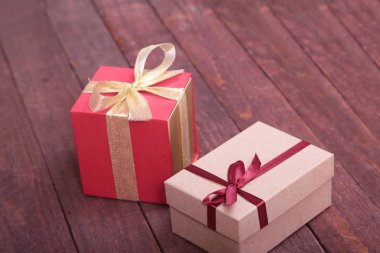 Ahşap arka plan üzerinde fiyonklu hediye kutuları