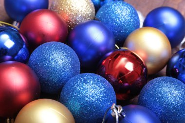 Ahşap arka plan üzerinde kırmızı, mavi ve altın Noel topları