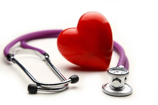 Heart with a medical stethoscope, isolated on wooden background — Stock Photo, Image