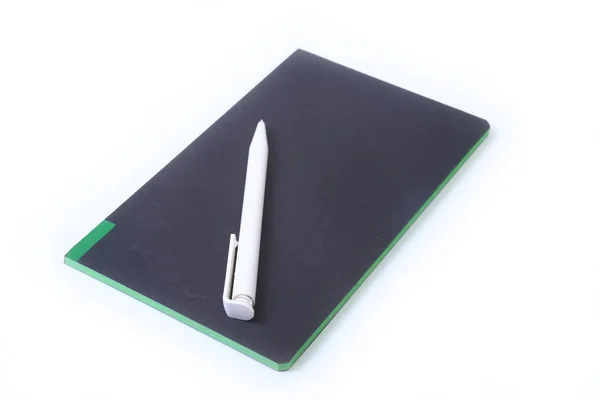 Cuaderno negro con pluma negra sobre fondo blanco —  Fotos de Stock