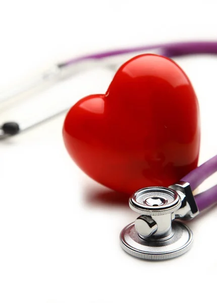Red heart and a medical stethoscope on desk — Stock Photo, Image