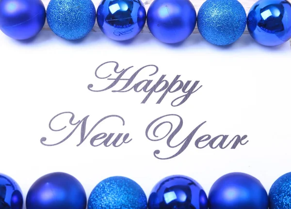 Текст с Новым годом на бумаге с большим количеством мячей — стоковое фото