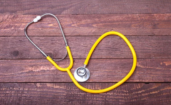 Sağlık stetoskop ve ahşap arka plan üzerinde izole Tablet — Stok fotoğraf