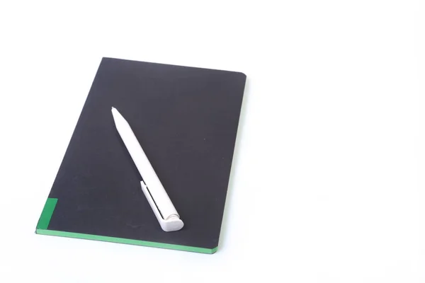 Черный ноутбук с черной ручкой на белом фоне — стоковое фото