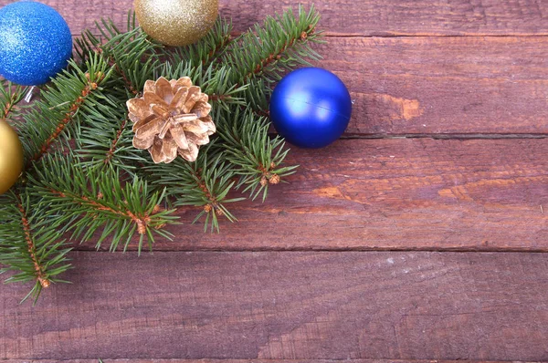 Fundo de Natal ou Ano Novo: árvore de pele, ramos, bolas de vidro coloridas, decoração e cones em um fundo de madeira — Fotografia de Stock