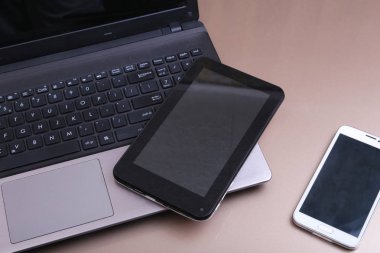 Bir telefon ve üstüne yalan tablet ile klavyenin resmi