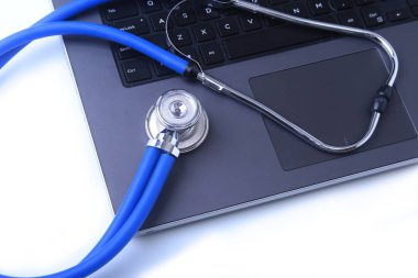 Beyaz ahşap bir masa üstünde a laptop yanında sağlık stetoskop