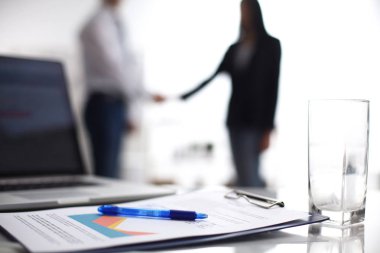 Dizüstü bilgisayar ile ağıl üstünde okul sırası, arka planda duran iki iş adamları